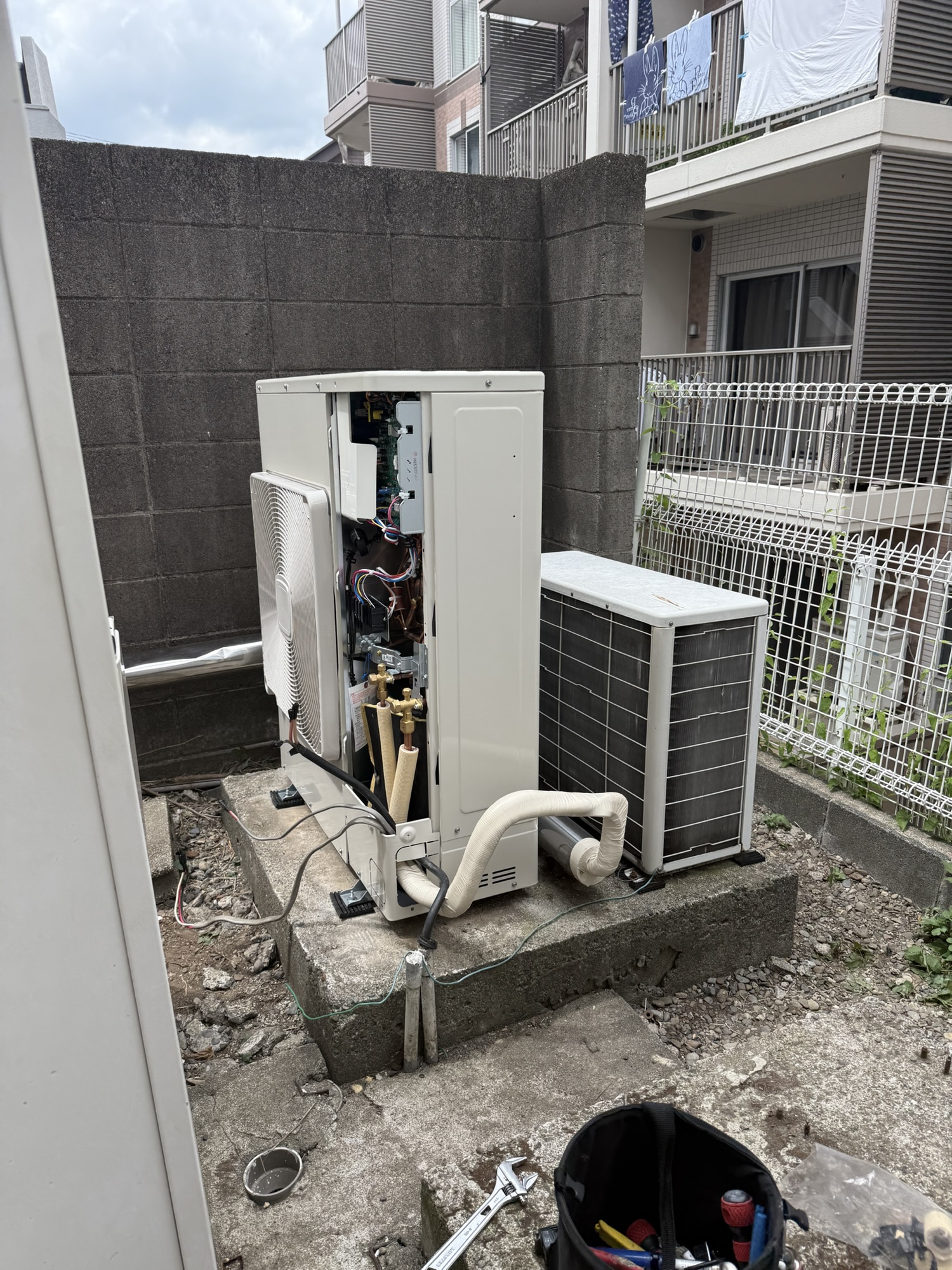 杉並区の業務用エアコン更新工事で室外機の配管作業中