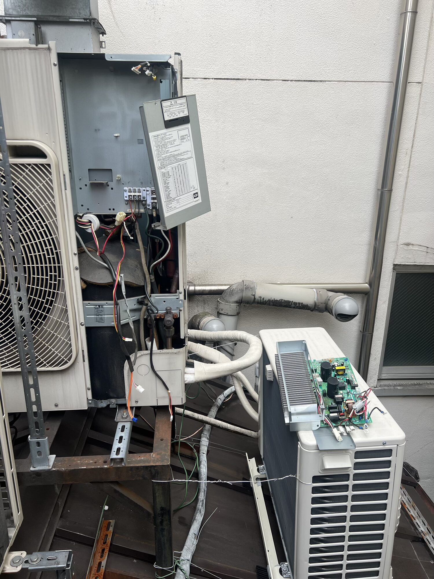 東芝キャリア業務用エアコンの室外機を開けて点検する様子