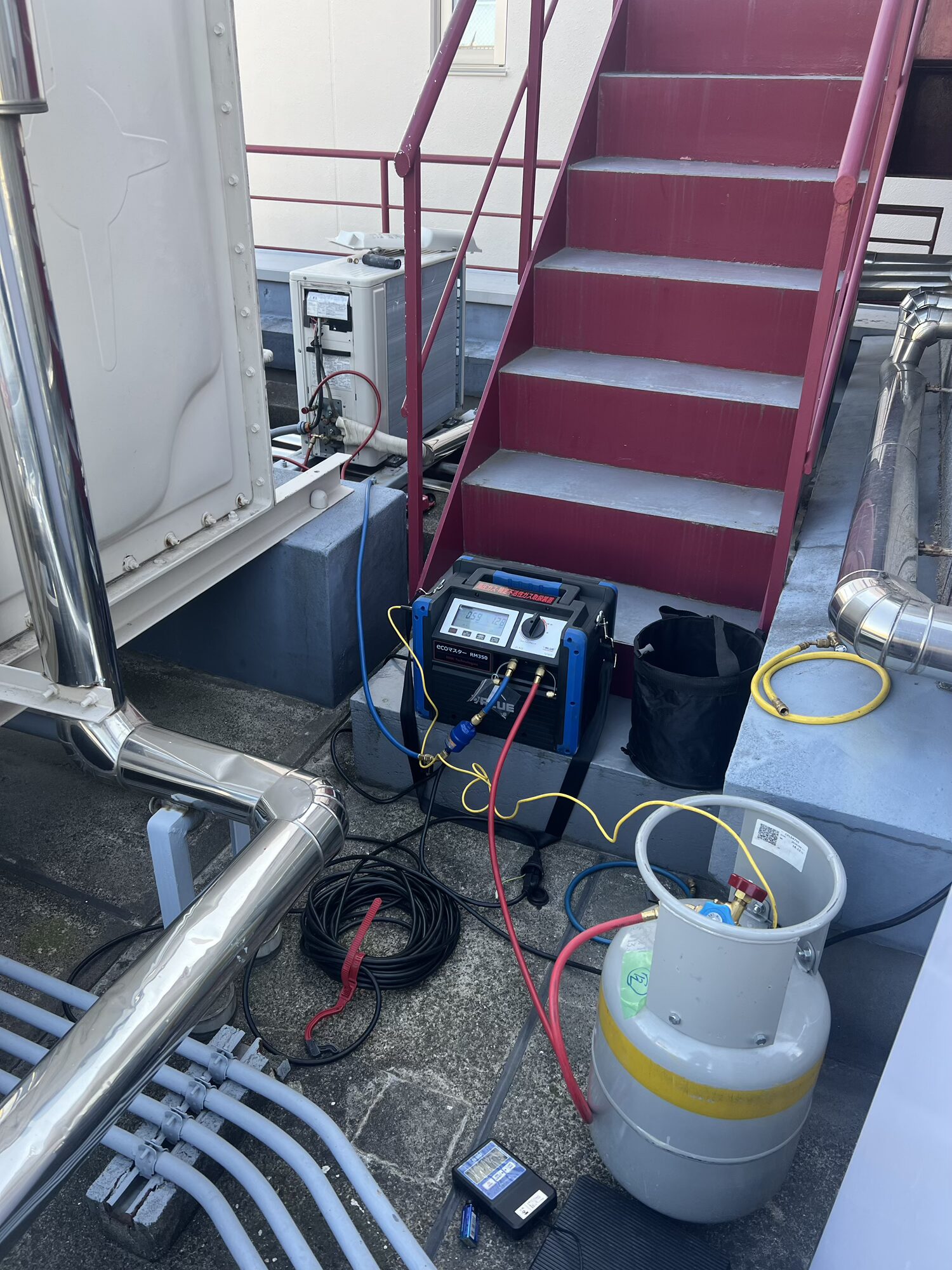 屋上に設置された業務用エアコンの点検現場
